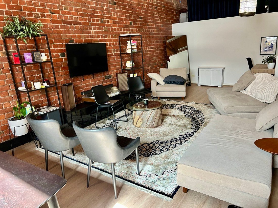 Lounge seating and armchairs arranged around a low round coffee table on a patterned rug